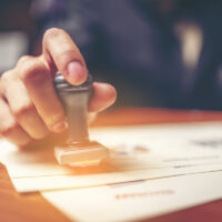 Close-up hand stamping of businessman for signing approval on documents , business concept